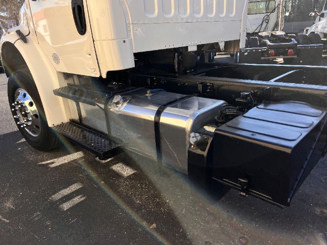 Side view of a 2015 Freightliner M2 cab and chassis showing a polished aluminum fuel tank and a large black toolbox under the cab.