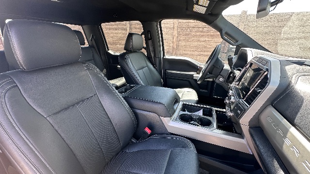 Interior of a 2022 Ford F-550 Lariat cab and chassis showing front seats, center console, and dashboard with touchscreen display.