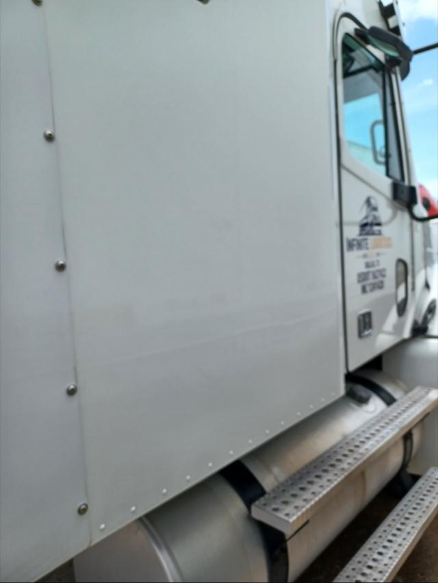 Truck cab side with chrome fuel tank and metal side step platform; Freightliner emblem and door area visible on the right.