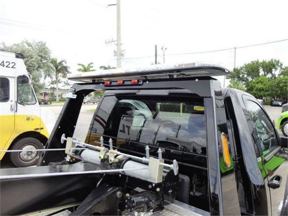 Ram 4500 pickup bed with tow hitch equipment and rear cab glass, tailgate removed, fluorescent yellow vehicle reflection.