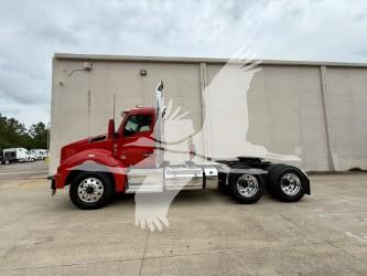 Kenworth T880 conventional daycab truck side view showing red cab with black chassis and multiple axles.
