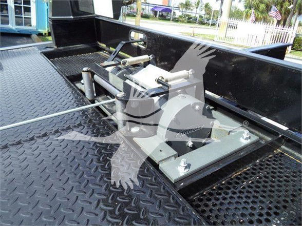 Tow truck bed winch/recovery winch mounted on diamond plate flatbed with hydraulic components and cables