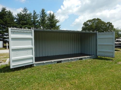 20' open side shipping container with doors open, empty interior showing corrugated metal walls and wooden floor, set on grass.