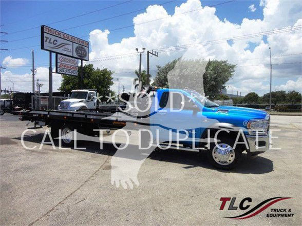 Flatbed tow truck with blue cab and black flatbed, TLC Truck & Equipment branding, 'SOLD CALL TO DUL ELE' watermark across image.