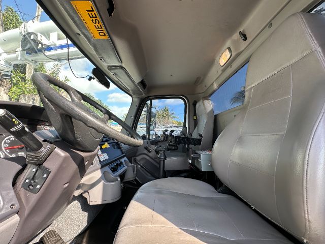Cab interior of a Freightliner 108SD truck showing steering wheel, dashboard, gray seats, and Diesel tag.