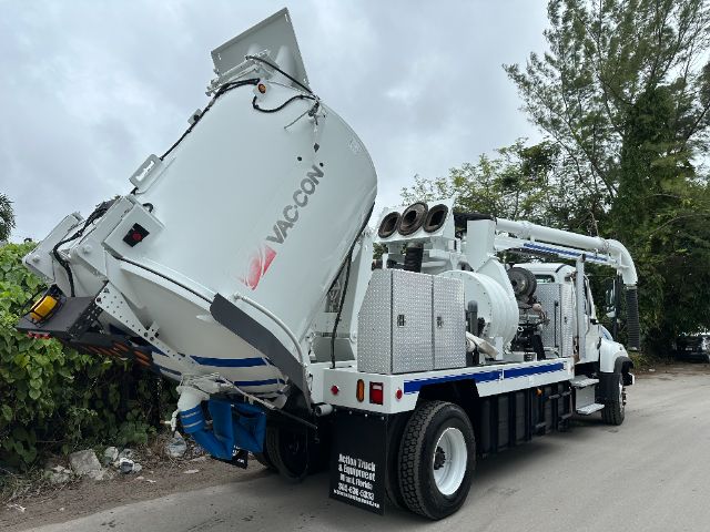 Venturi vacuum truck with a large white hopper and rear hose reels; text on hopper reads VAC-CON. Side compartments and controls visible.