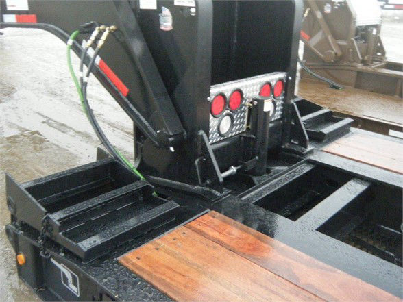 Talbert 55SA flat level deck trailer showing hydraulic lift and wooden deck planks, with control panel and hoses.