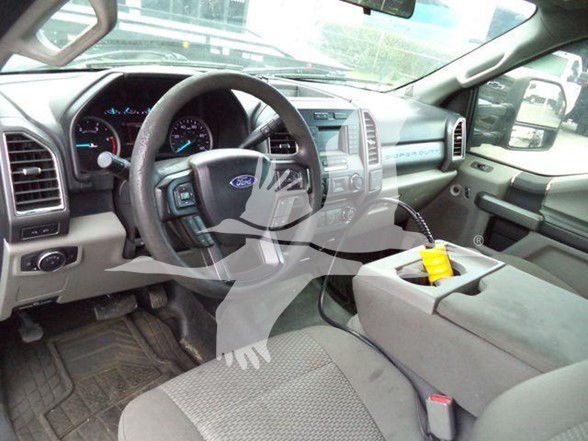 Ford F-450 interior cabin with steering wheel, dashboard, center console, and gear shifter visible.