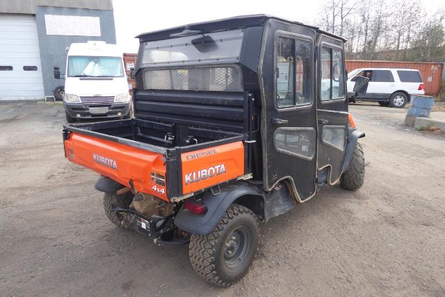 Kubota RTV-X1140 utility vehicle with orange cargo bed and black cab, rear view showing taillights and off-road tires.