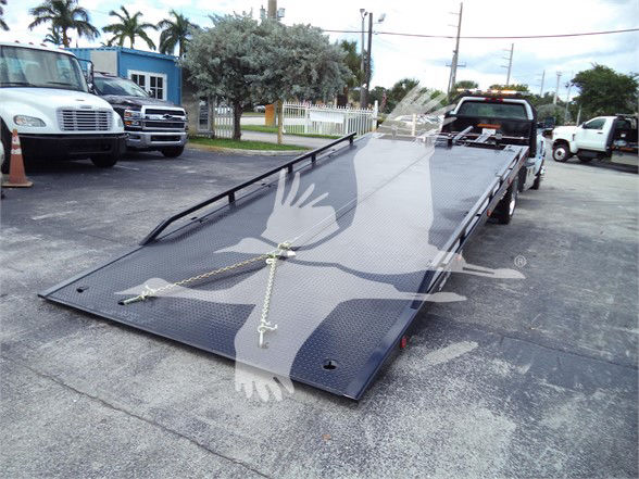 Flatbed tow truck bed with loading ramps and tiedowns, Chevrolet Silverado 6500HD listing image.
