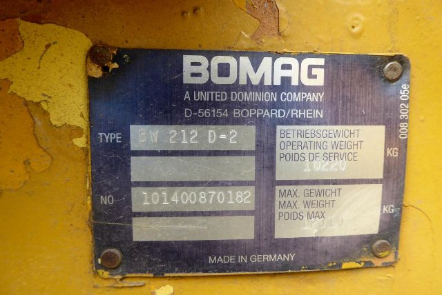 Bomag plate on yellow equipment showing model BW 212 D-2, serial number 101400870182, made in Germany, with fields for operating weight and max weight.