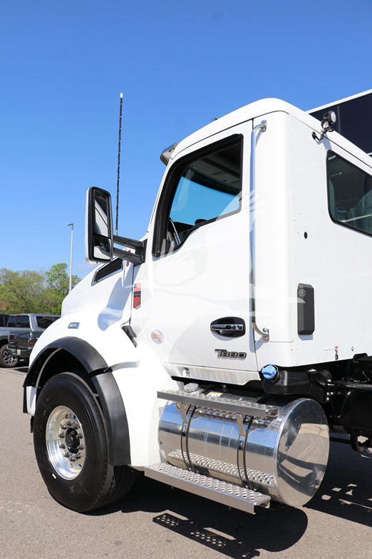 Kenworth T880 cab and chassis side view showing front wheel, chrome fuel tank, and door with Kenworth badge.