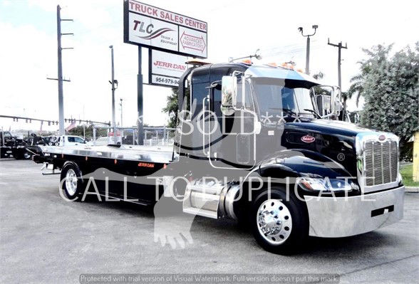 2022 Peterbilt 337 tow truck in black with flatbed, chrome grille, and large front wheels visible. 'SOLD' watermark across the cab and flatbed.
