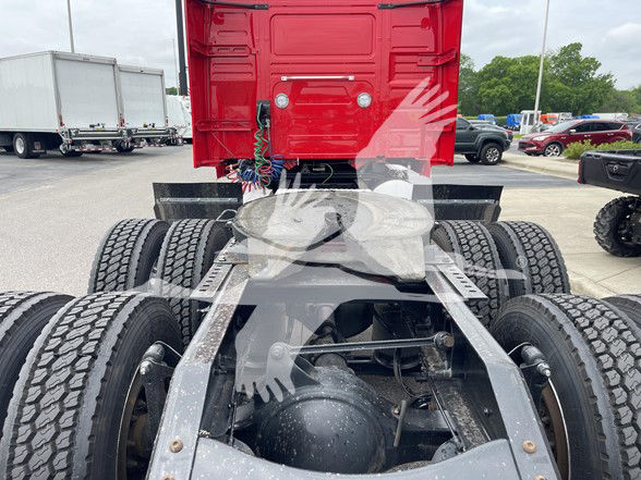 Volvo VNL64T740 truck chassis rear view showing fifth wheel, dual rear axles, and fuel/air lines near frame.
