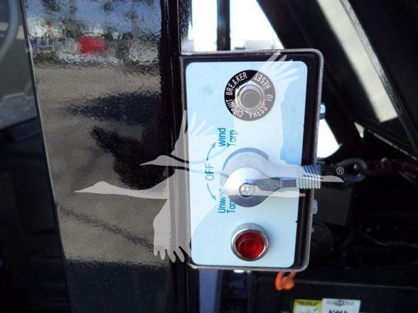 Panel on Isuzu truck door with blue and white control box showing 'Wind' 'Off' and 'On' labels, red indicator button, and a lock knob labeled 'BREAKER'