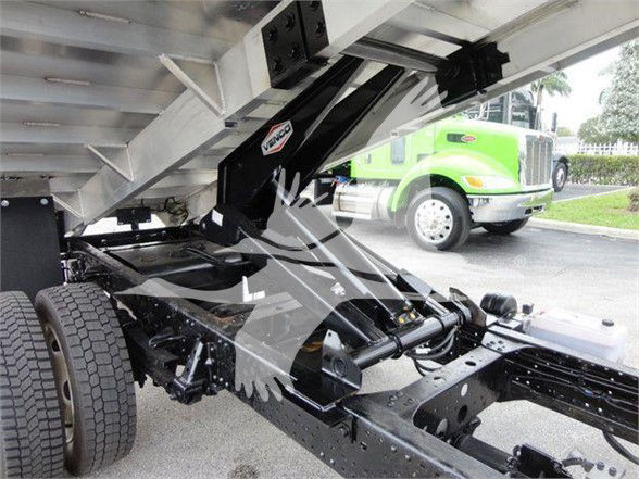 Isuzu NQR dump truck chassis and hydraulic dump mechanism with exposed frame and suspension components.