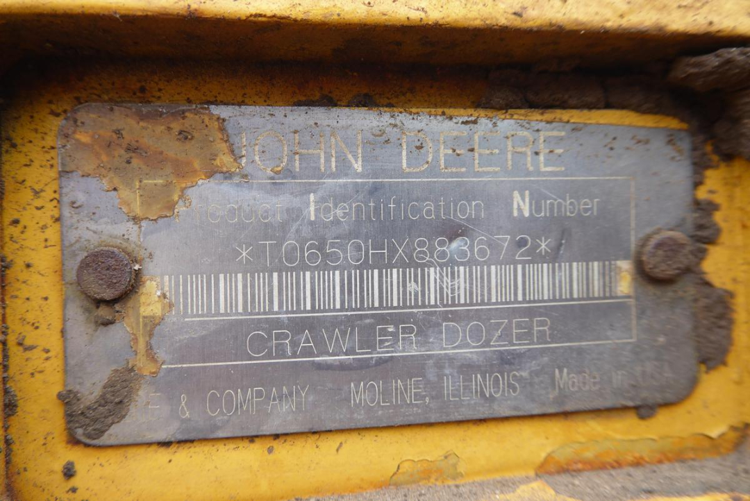 John Deere production identification plate on a yellow crawler dozer showing model information and serial number.