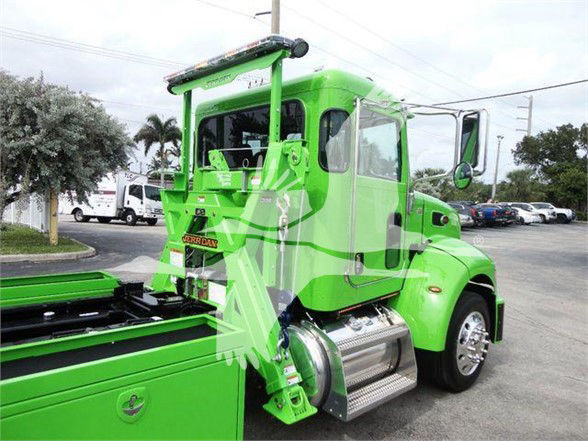 Peterbilt 337 tow truck in bright green with chrome fuel tanks and side steps, cab rear view
