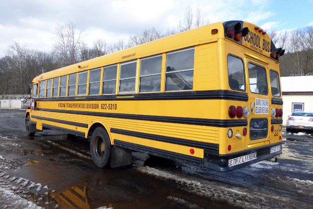 1992 Freightliner FS65 school bus rear three-quarter view showing yellow exterior with black stripes and school bus signage.