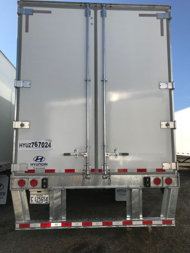 Rear view of a Hyundai Translead trailer with closed double doors, license plate HYU Z676024, and reflective red/white tape along the lower edge.