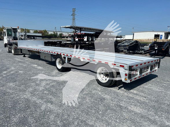 2019 Reitnouer Dropmiser trailer with flatbed, long bed, side rails, and dual rear axles under bright daylight. VIN/stock not visible on the trailer.