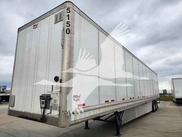 Trailer side and rear showing large white Wabash van trailer with loading doors and support legs.