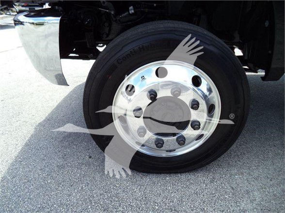Wheel and tire assembly on a new 2023 International CV truck showing chrome hubcap and Conti tire, with stock number CV515CREW14SNG2.