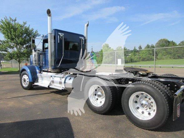 Kenworth W900L tractor with blue cab and chrome fuel tanks, showing side view of rear dual axles and wheels.