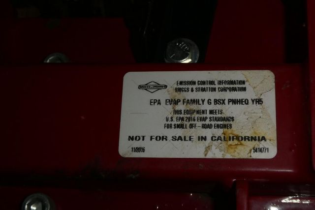 Label on equipment showing emission control information with EPA label and notes; some text is smudged.
