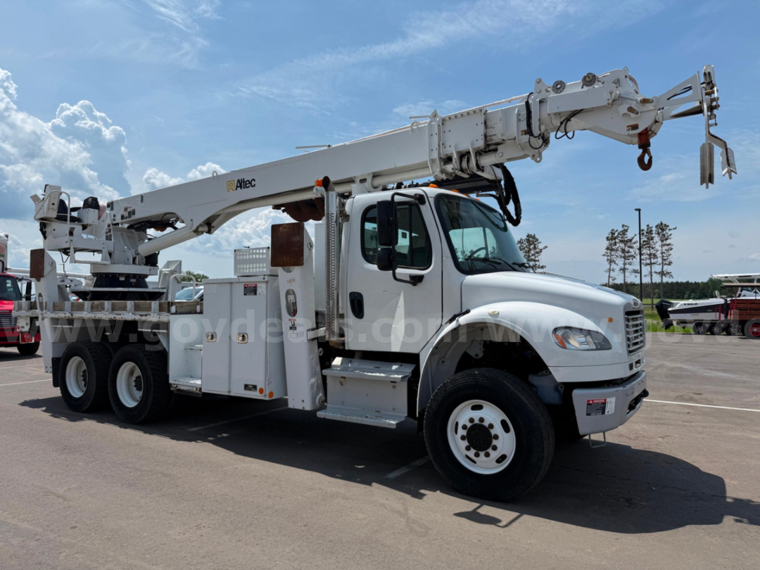 Altec DT65 boom truck on Freightliner chassis showing hydraulic crane arm and equipment compartments.