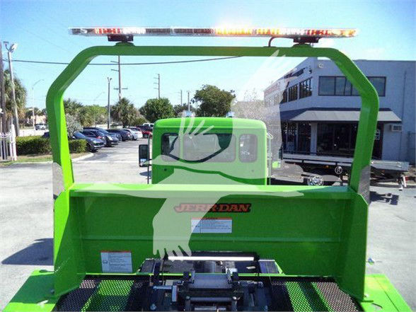 Kenworth T280 tow truck rear view with bright green body, rear loading platform, and Jerr-Dan logo visible.