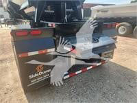 Trailer hitch area showing SideDraw brand logo and rear of dump trailer with taillights and reflections.