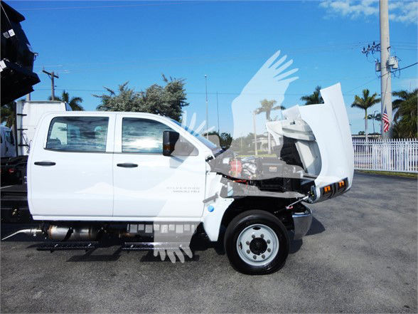 2023 Chevrolet Silverado 5500HD in white with hood open and cargo area exposed, side view showing dual rear wheels and cab doors.