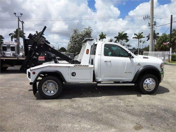 2024 Ram 4500 SLT tow truck side view showing wheel chrome rims and hydraulic tow equipment with 'JERRDAN' labeling on white truck.