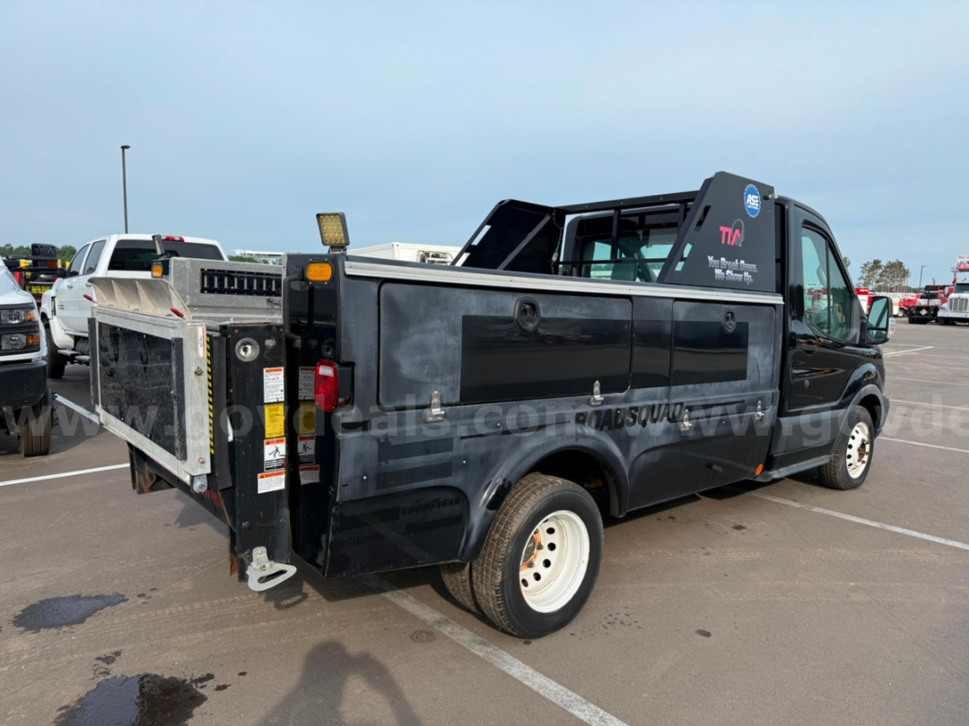 Ford Transit utility bed on service truck with aluminum ramp and spare wheel, cargo doors, and work side panel.
