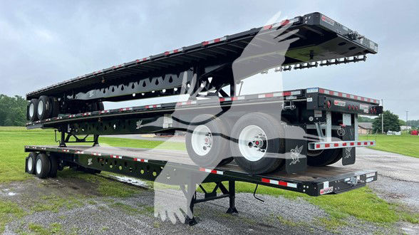 Flatbed trailer stacked on another trailer with multiple axles and wheels visible; no legible text on the trailer sides from distance.
