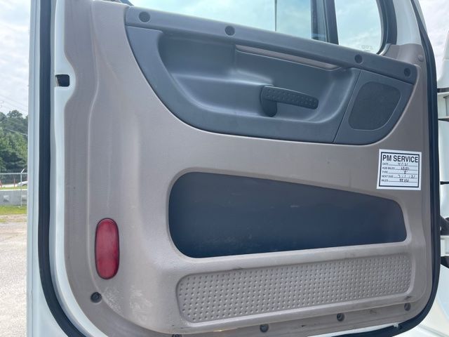 Truck door interior panel with PM SERVICE sticker and vehicle features visible.