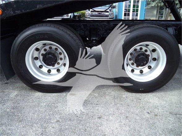 Twin rear dual wheels of a Peterbilt truck chassis with white rims and black tires, showing the inner components and wheel hubs.