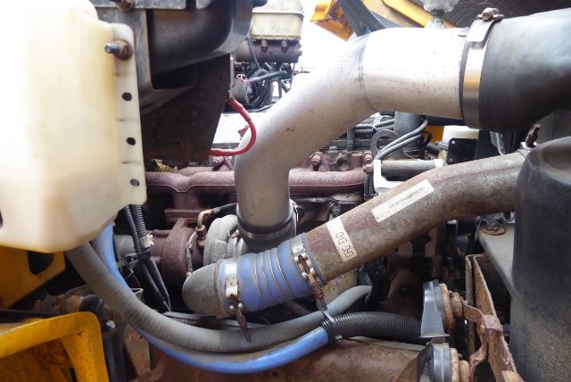 Engine bay showing cooling hoses and intake pipe in a Freightliner FS65 engine area.