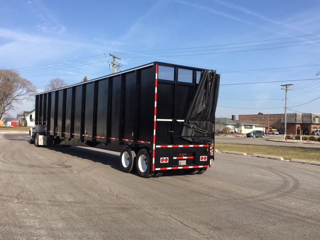 2002 Great Dane single drop trailer in a parking lot showing black dump trailer with red/white reflective tape and rear ramp/doors.