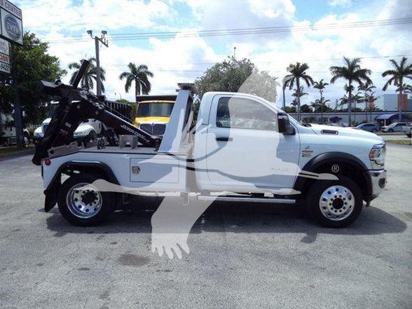 Ram 4500 tow truck side view showing wreckers and lift equipment attached to rear chassis, white paint, clear cab with extended cabin, Dually rear wheels.
