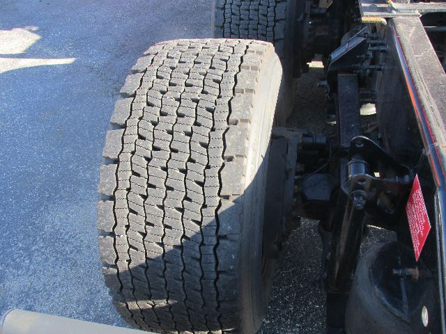 Volvo truck rear wheel and chassis visible; tread pattern on dual tire; part of suspension and frame visible.