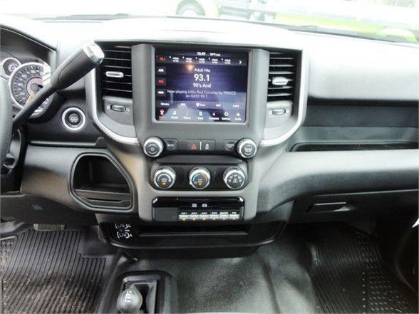Dashboard of a 2024 Ram 4500 SLT showing central touchscreen and climate controls. Visible controls, gear lever area, and floor mats.