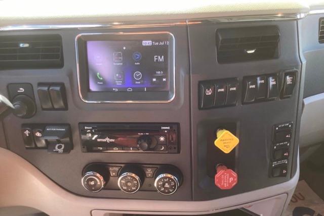 Peterbilt 579 cab dashboard with multimedia touchscreen, climate controls, and auxiliary switches.