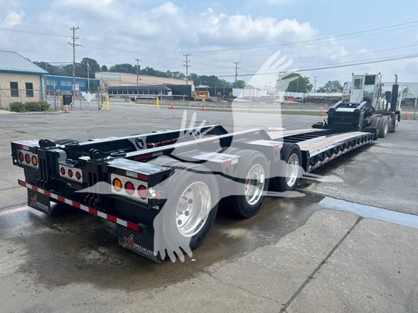 XL Specialized Xl110Hdgs18 trailer with multiple axles, rear lights, and hydraulic tilt components visible. Includes branding near mudflaps and reflective tape.