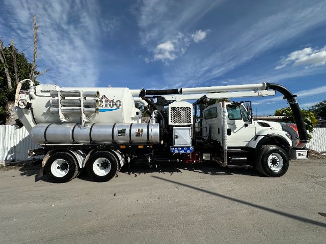 Industrial vacuum truck with large white cylindrical tank and boom, International 7500 chassis, side view.