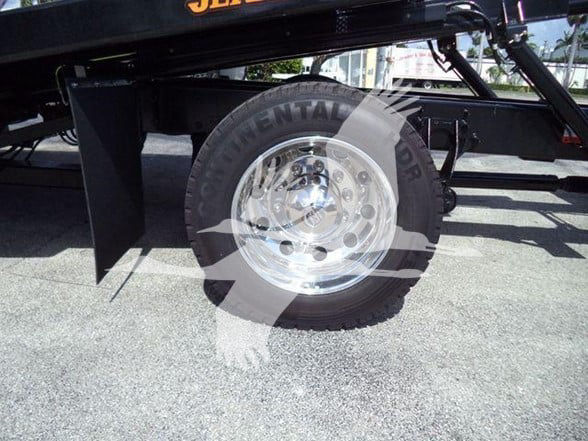 Wheel well and chrome wheel on tow truck chassis with large tire; some text on the tire reads 'CONTINENTAL' around the sidewall.