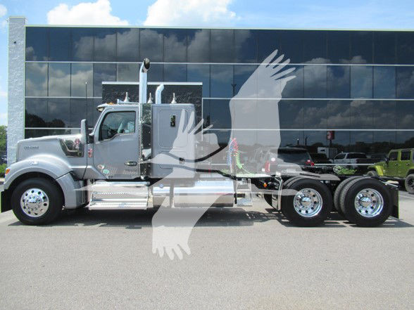 Kenworth W990 conventional sleeper truck side view showing chrome mirrors exhaust stacks and tandem rear axles.