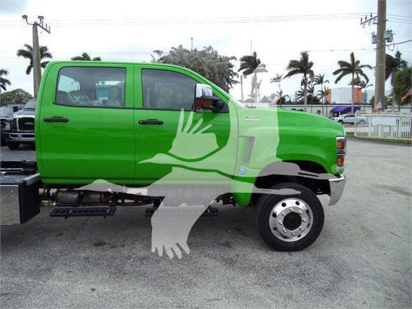 Green 2023 International CV truck side view with logos and side mirrors visible.