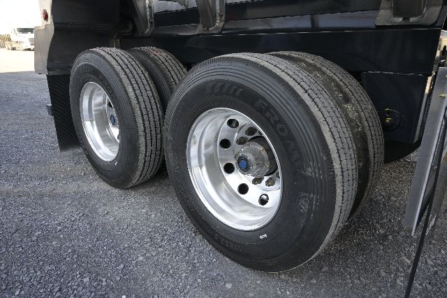 TRUXTON 150BBL aluminum vacuum trailer wheel assembly showing dual rear axles with polished steel rims and black tires.
